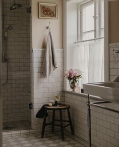 a bath room with a stand up shower next to a window