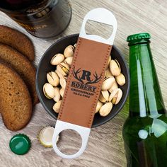 a bottle opener sitting on top of a table next to some food and a beer