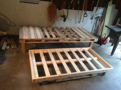 two tables made out of wooden pallets in a garage