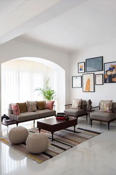 a living room filled with furniture and pictures on the wall