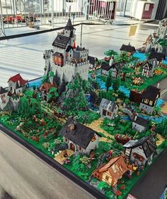 a model of a town made out of legos on display in a building with lots of windows