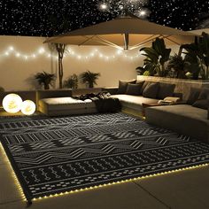 a living room filled with lots of furniture and lights on the ceiling above it's carpet