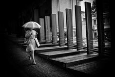 a black and white photo of a woman with an umbrella