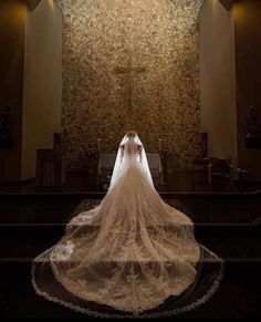 the back of a bride's wedding dress in front of a wall with lights