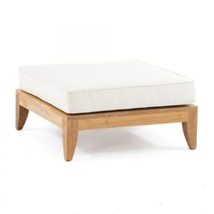 a wooden footstool with a white cushion on it