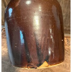 a brown vase sitting on top of a wooden table