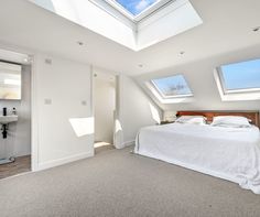 an attic bedroom with skylights and a bed