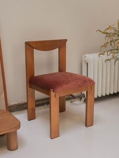 a wooden chair sitting next to a radiator