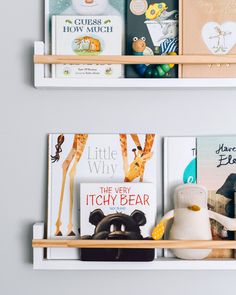 two wooden shelves with books and toys on them in a child's room or playroom