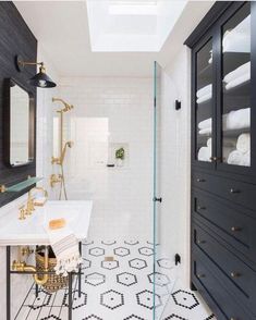 a black and white bathroom with gold accents