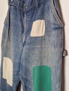 an old pair of jeans with patchwork on the side and green patches on the back