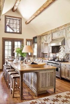 a large kitchen with wooden floors and an island in the middle of it, surrounded by wood beams