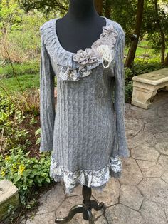 This sweater is made of a cozy 45% wool/55% poly yarn.  It's lined except for the sleeves, and the ruffled, asymmetrical collar also features lace, 3-d flowers and pearls.   Shoulder to shoulder 16" Bust 38" Waist 32" Hips 40" Length 33" Sleeves 18" under the arm; 25" along the top Fitted Long Sleeve Sweater With Lace Trim, Fitted Fall Sweater With Lace Trim, Fall Sweater With Lace Trim Long Sleeve, Knit Long Sleeve Sweater With Lace Trim, Fitted Knit Sweater With Crochet Trim, Long Sleeve Knit Sweater With Lace Trim, Winter Knit Sweater With Lace Trim, Fall Long Sleeve Sweater With Lace Trim, Fitted Sweater With Crochet Trim For Fall