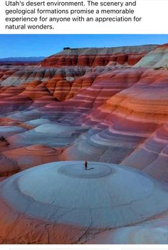 a person standing in the middle of a desert with red and orange rocks behind them