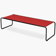 a red table sitting on top of a white floor next to a black metal frame