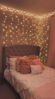 a bed with pillows and lights on the wall