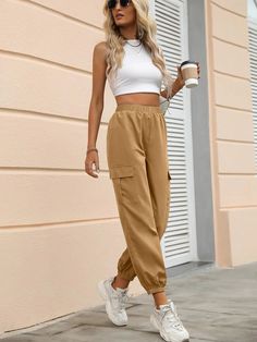 Introducing our Elastic Waist Joggers, the epitome of comfort and style. These joggers effortlessly combine practicality with a touch of sophistication, making them a must-have addition to your wardrobe. Crafted with meticulous attention to detail, these joggers feature a high waist design that flatters your silhouette and accentuates your natural shape. The cropped length adds a modern twist, allowing for easy movement and showcasing your favorite footwear. Specifications: Details: Button, Pock Spring Tapered Leg Joggers With Cargo Pockets, Athleisure Cargo Style Joggers, Trendy Cargo Style Sweatpants For Loungewear, Fall Athleisure Joggers With Cargo Pockets, Spring Joggers With Elastic Waistband And Cuffed Ankles, Cargo Style Athleisure Joggers, Casual Solid Joggers With Elastic Side Panels, Casual Joggers With Elastic Side Panels, Trendy Solid Joggers With Tapered Leg