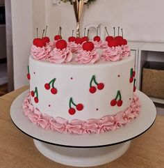 a cake decorated with cherries and pink ruffles