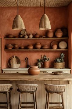 a kitchen with two stools and some baskets on the shelves above it, along with pots and pans