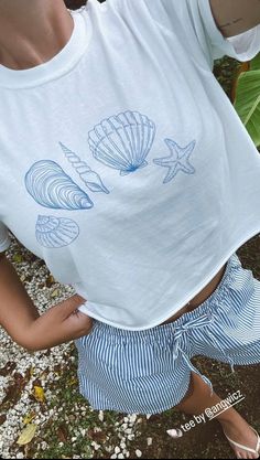 Seashells by the sea shore...wishing I was at the beach collecting shells but this will do! 🐚 - Comfort Colors - White or Ivory with blue seashells design - Model is wearing Ivory - Gets cozier the more you wear it! - 100% ring-spun cotton - soft-washed, garment-dyed fabric - Heavy fabric (6.1 oz/yd²) - Relaxed fit - Sewn-in twill label The soft-washed, garment-dyed fabric brings extra coziness to your wardrobe while the relaxed fit makes it an excellent daily choice. The double-needle stitching throughout the tee makes it highly durable while the lack of side seams helps the shirt retain its tubular shape. Nautical Beach Tops For Summer, Nautical Style Beach Tops For Summer, Nautical Tops For Beach In Summer, White Nautical Tops For Vacation, Nautical Short Sleeve Beach Top, White Tops For Ocean Activities In Summer, Nautical Blue Top For Beach, White Casual Shell For Beach Season, Casual White Shell For Beach Season