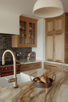 a bowl of fruit sitting on top of a kitchen counter next to a sink and oven