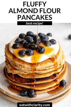 a stack of pancakes with blueberries on top and syrup drizzled over them