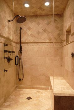 a walk in shower sitting next to a tiled wall and floor with two faucets