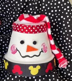 a close up of a snowman hat on a polka dot seat cover in a child's car seat