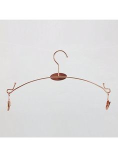 a metal hanger with two pairs of shoes hanging from it's end, on a white background