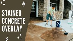 a man with a mop is cleaning the concrete in front of a house that says stained concrete overlay