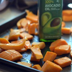 sliced up carrots on a tray next to a bottle of avocado oil