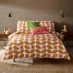 a bed with an orange and pink comforter