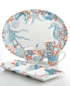 an ocean themed dinnerware set with blue and red designs