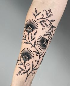 a woman's leg with tattoos on it and flowers in the middle of her legs