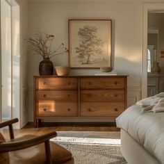 a bedroom with a bed, dresser and chair