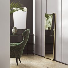 a room with a chair, mirror and potted plant