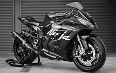 a black motorcycle parked in front of a garage