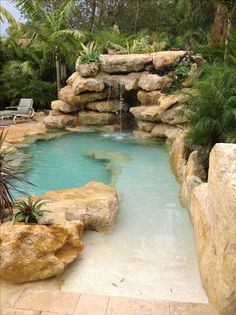 a small pool surrounded by rocks and plants