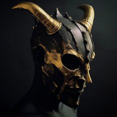 a mask with horns on it is shown in black and gold colors, against a dark background