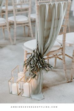 the chairs are decorated with candles and greenery for an elegant wedding ceremony at ambience events