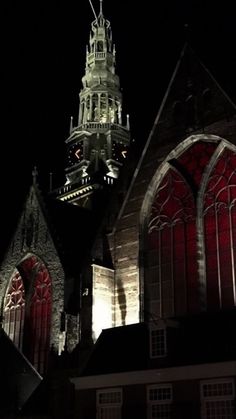 an image of a church at night with red lights on the windows and steeple