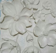 some white clay flowers and leaves on a table