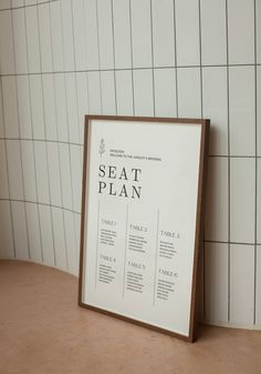 a seat plan sitting on top of a table next to a white tiled bathroom wall