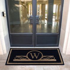 a door mat with the letter w on it in front of a glass entry door