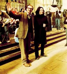 a man and woman are standing in front of some stairs with their hands up to the sky