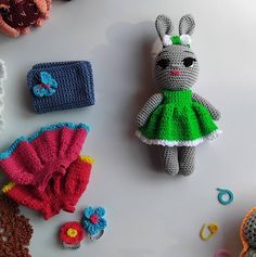 several crocheted items are laid out on a table, including a stuffed rabbit