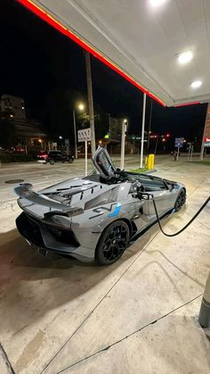 a silver sports car parked at a gas station