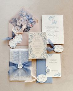 the wedding stationery is laid out on top of each other with ribbons and flowers