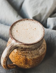 a brown and white mug sitting on top of a gray blanket