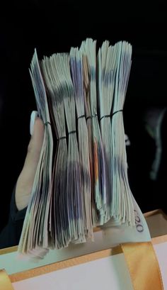 a person holding up stacks of money in their hand